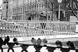 Woman standing on a bridge over Griboyedov Canal, St. Petersburg, Russia.