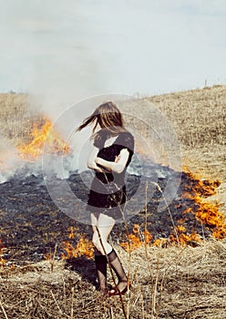 Woman standing in burning field, lifestyle people concept