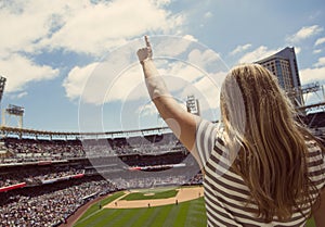 Woman standing and cheering at a baseball game