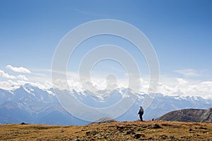 Woman standing on a cliff edge high up in the mountains