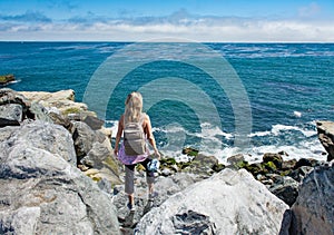 Woman hiker relaxing by the Pacific ocean in California. photo
