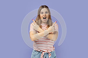 Woman standing with crossed hands and pointing to empty space for promotional text on both sides.