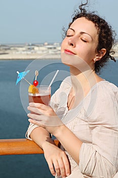 Woman standing on cruise liner with cocktail