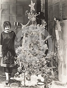 Woman standing by decorated Christmas tree