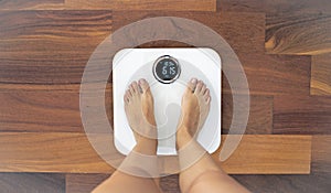 Woman standing on a digital scale with body fat analyzer