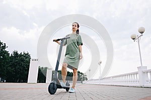 Woman standing with an electric scooter outdoor.