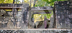 Woman standing in entranceway of stone amphitheater in sarong photo