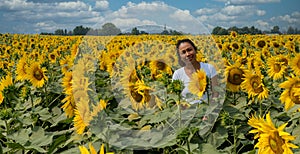 Woman standing in field surrounded by sunflowers