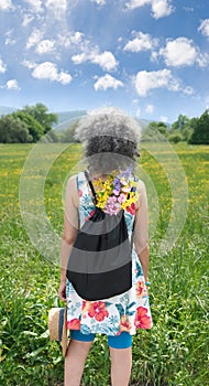 Woman standing in field with yellow flowers Blue sky