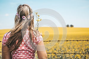 Woman standing by fields of flowering canola in Spring