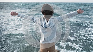 Woman standing in front of amazing seascape