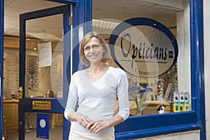 Woman standing at front entrance of opticians