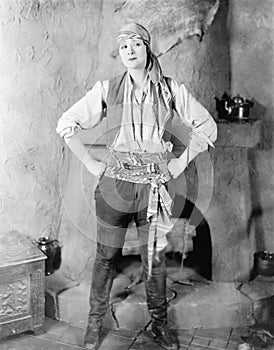 Woman standing in front of a fireplace in a pirates costume