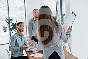 Woman standing in front of her employees. Group of business people that working on the project in the office