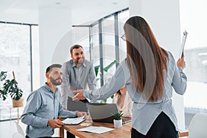 Woman standing in front of her employees. Group of business people that working on the project in the office