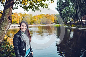 Woman standing in front of lake in warm autumn weather