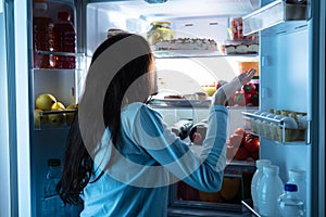 Woman Standing In Front Of Refrigerator Shrugging