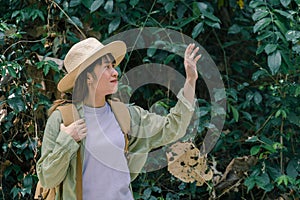 Woman standing happily among the forest Travel Lifestyle, waving hello. Wellness Concept
