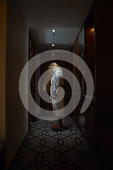 Woman standing, head bowed, in the Hallway