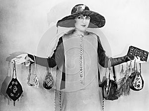 Woman standing with her arms apart wearing handbags