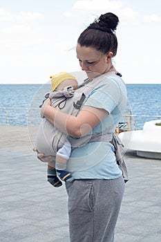 woman standing with her baby in sling