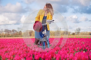 Woman standing with her bike in tulips fields