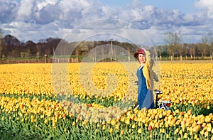 Woman standing with her bike in tulips fields