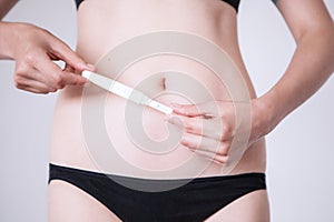 Woman standing and holding a pregnancy test