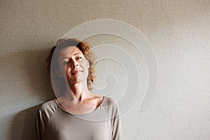 Woman standing inside with pensive expression