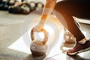 Woman standing on knee and preparing for cross fit exercise