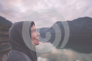 Woman standing by the lake with hopeful look in eyes