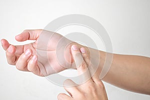 Woman standing listening to the pulse of the hand on a white background. Side view