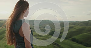 Woman standing on lush green hillside