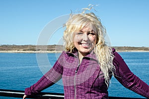Woman standing on the Marthas Vineyard ferry, enjoying the wind blowing her blonde hair