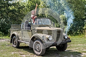 Woman standing in military car posing outdoors