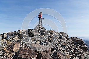 Woman Standing On Mountain Summit Cairn