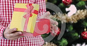 Woman standing near Christmas tree with red New Year gift in her hands 4k movie