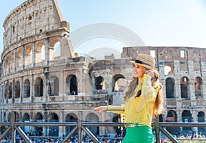 Woman standing near Colosseum in Rome listening to music