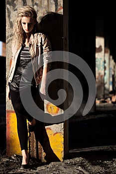 Woman standing near column wearing leather jacket
