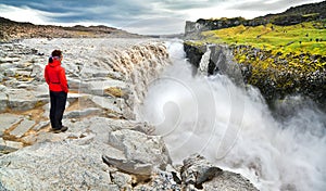 Woman standing near famous Dettifoss waterfall in Vatnajokull National Park, Iceland photo