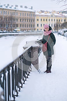 A woman standing near Griboedov Canal in winter, St. Petersburg, Russia.