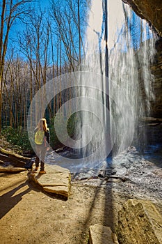 Woman standing near Moore Cove Waterfall in Pisgah National Forest near Brevard NC
