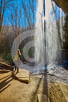 Woman standing near Moore Cove Waterfall in Pisgah National Forest near Brevard NC