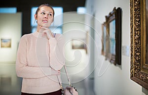 Woman standing near painting in art museum