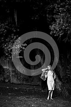 Woman standing near a tree in a garden. Black and white photo.