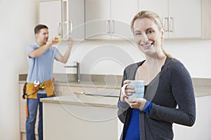 Woman Standing In New Luxury Fitted Kitchen