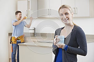 Woman Standing In New Luxury Fitted Kitchen photo