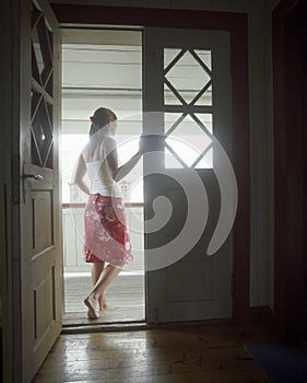 Woman Standing In Open Door