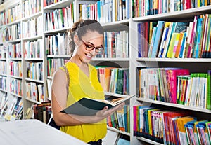 Woman standing with open in publishers store photo