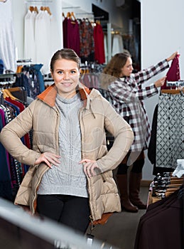 Woman standing in overcoat in boutique